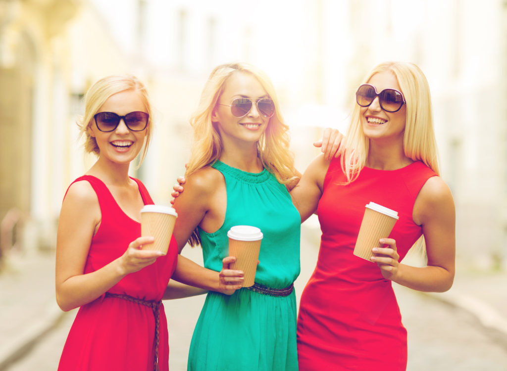 holidays and tourism, friends, blonde girls concept - beautiful women with takeaway coffee cups in the city